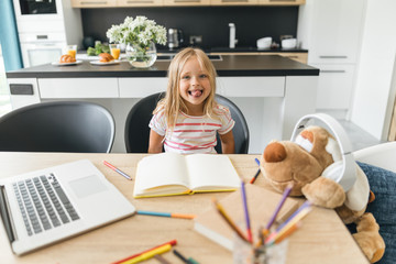 Funny girl showing tongue at the table stock photo