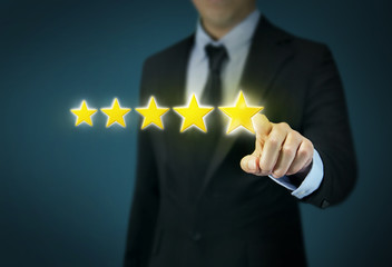 Businessman hand touching five star symbol to increase rating of company concept.