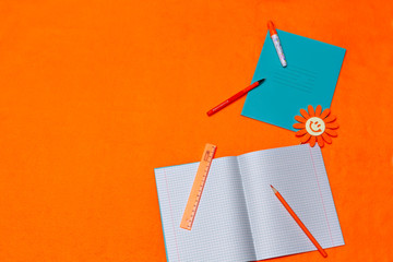 Back to school with copybooks and accessories for study on a bright orange background. Copy-space. Place for text.
