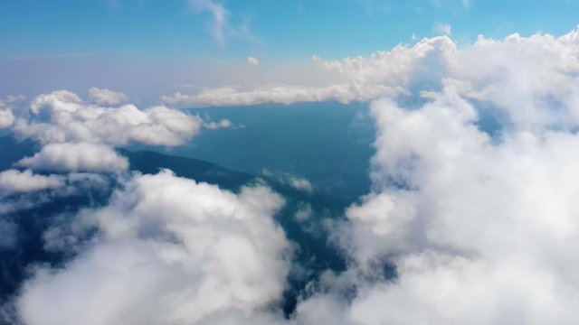 Flying through heavenly beautiful cloudscape. Picturesque timelapse of white fluffy clouds moving softly on the clear blue sky in pure sunshine. Direct view from the cockpit.