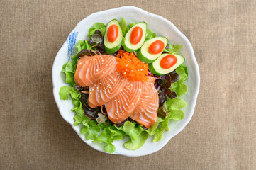 Raw Salmon sashimi with vegetable in ceramic bowl