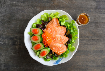 Raw Salmon sashimi with vegetable in ceramic bowl