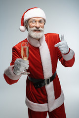 Mature Santa Claus holding glass of champagne