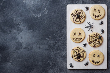 Homemade cookies for Halloween. Cookies with funny faces and spider webs. Copy space.