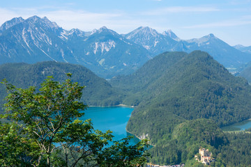 Beautiful summer day in bavarian Alps with a view to Alpsee lake and Neuschwanstein castle Germany from hiking trail