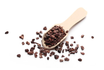 Chopped cocoa pile with wooden spoon isolated on white background