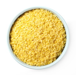Millet flakes in bowl isolated on white background, top view