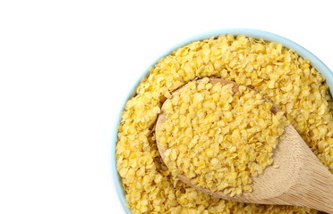 Millet flakes in bowl with wooden spoon isolated on white background, top view