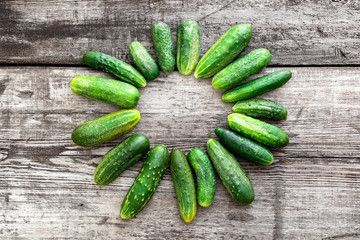 Top view fresh farm cucumbers on wooden background, copy space. 