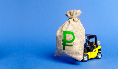 Yellow forklift truck carries bag of russian ruble money. Attracting investment in development,...