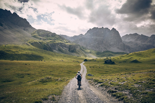 Mountain Biker on Road in Swiss Alps
