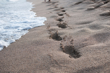 Fototapeta na wymiar Human footprints in the sand on a coastline
