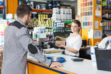 Woman seller standing at the counter and consulting  male