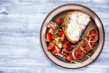 Grilled sausage, toast and vegetable salad
