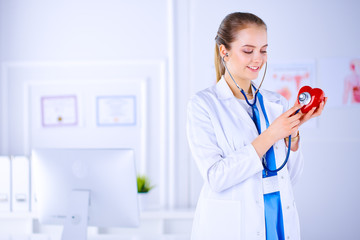 Doctor cardiologist examines the heart with a stethoscope. Young female doctor in a hospital