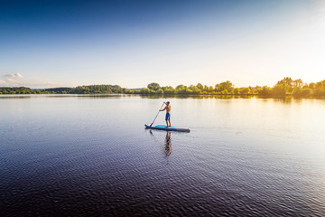 Germany, Bavaria, Allgaeu, standup paddler at the Frankenhofner lake at sunset