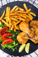 Grilled chicken drumsticks with french fries and vegetables