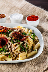 Pasta with chicken meat, sun-dried tomatoes and rucola