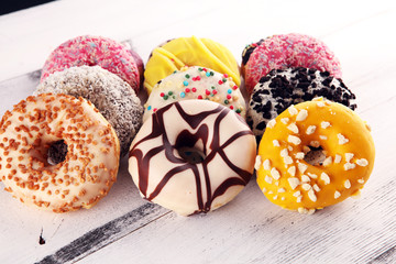 assorted donuts with chocolate frosted, pink glazed and sprinkles donuts