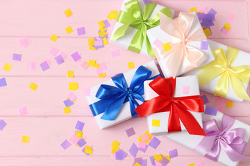 gifts and confetti on a colored background top view. Holiday giving gifts