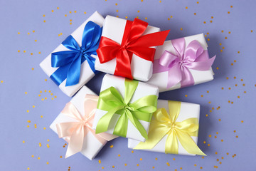 gifts and confetti on a colored background top view. Holiday giving gifts