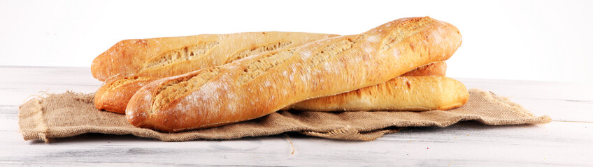 Assortment of baked bread and bread rolls on white table background