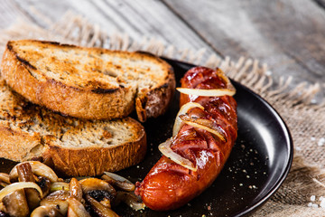 Grilled sausage, toasts and mushrooms