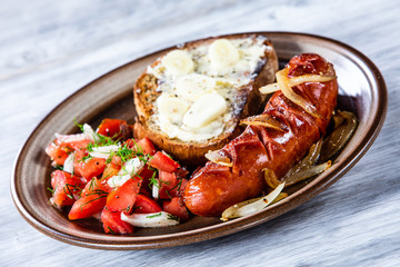 Grilled sausage, toast and vegetable salad