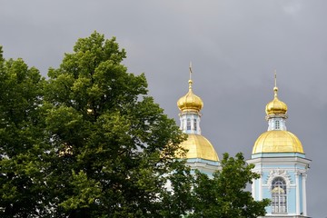 Zwei Türme der Nikolaus-Marine-Kathedrale in Sankt Petersburg hinter Bäumen