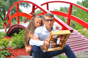 Boy and first-grader girl with large abacus. Thoughtful schoolboy and schoolgirl using a maths abacus calculation