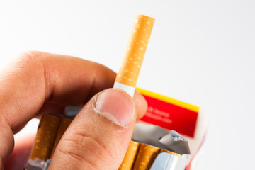 Caucasian man hand catching a cigarette isolated on white background. Tobacco can cause diseases in the organism.