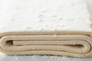 Fresh raw dough on table. Puff pastry. Copy space.