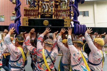 People who are lifting a portable shrine at a Japanese traditional festival, Japan