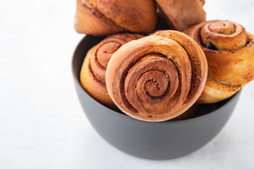 Cinnamon rolls buns in grey bowl. Macro focus.