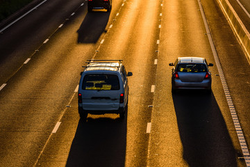 long shadows of car traffic on uk motorway at sunset in england