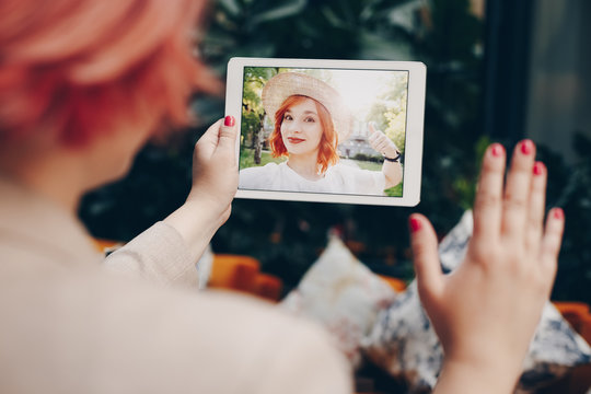 Young woman using a tablet by having a video call chat with her girlfriend who is away. Concept of keeping a long distant same sex relationship.