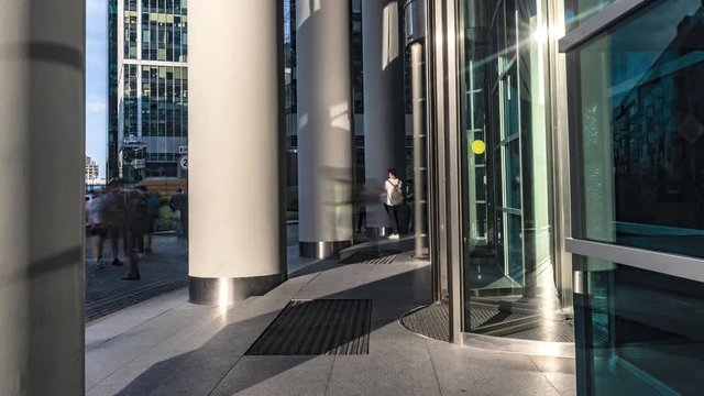  the flow of people passing through the revolving door of the modern office building at the end of the working day,time lapse