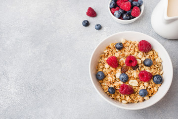 Healthy breakfast. Fresh granola, muesli with yogurt and berries on grey background. Copy space