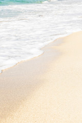 Soft foamy wave on the sandy shore. Background, space for text. Vertical.
