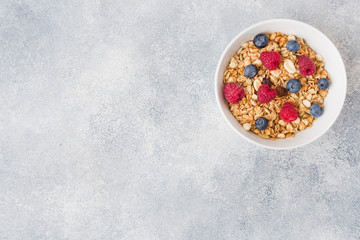 Healthy breakfast. Fresh granola, muesli with yogurt and berries on grey background. Copy space