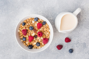 Healthy breakfast. Fresh granola, muesli with yogurt and berries on grey background. Copy space