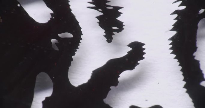 black organic structures on a white background forming unnatural excrescences. black liquid floating around building spikes. ferrofluid forming different structures