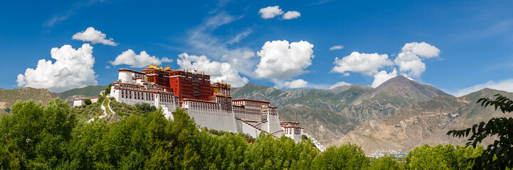 LHASA, TIBET / CHINA - July 31, 2017: Panorama of Potala Palace - home of the Dalai Lama and Unesco World Heritage. Blue sky, clouds. Amazing view of the ancient fortress. Center of Tibetan Buddhism. - obrazy, fototapety, plakaty