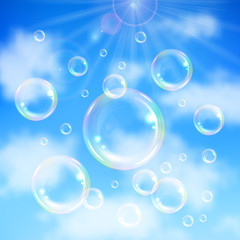 Realistic transparent floating soap bubbles on blue sky background. Design element for advertising booklet, flyer or poster