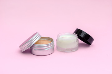 Blank silver and glass cream jar on light pink background. Cosmetic skincare products, modern concept of organic beauty trend.