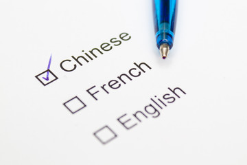 Chinese, French, English - checkmark with pen on paper.