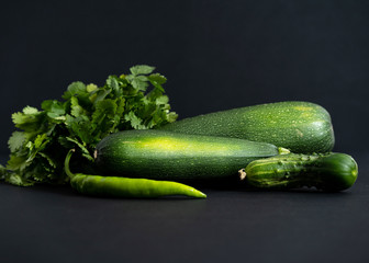 whole green vegetables on a black background, close-up top view, copy space, horizontal frame
