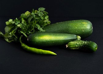 whole green vegetables on a black background, close-up top view, copy space, horizontal frame