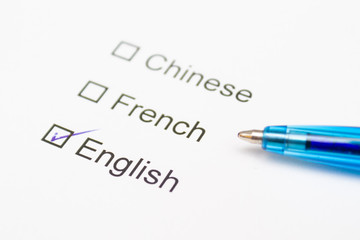 Chinese, French, English - checkmark with pen on paper.