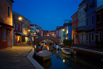 Old colorful houses and boats at night in Burano, Venice Italy.